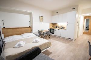 a bedroom with a large bed and a kitchen at MamaStay Andel Apartments in Prague