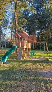 a playground with a slide and a house at Letniaczki ABI in Rydzewo