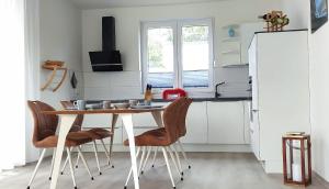 eine Küche mit einem Tisch und Stühlen sowie einem Kühlschrank in der Unterkunft Hangar 19 Wohnung Seerose 2-3 in Schwerin