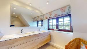 a bathroom with a sink and a large mirror at Strandhaus Höltig in Hörnum +18 photos