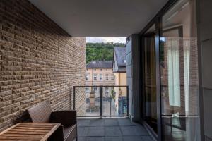 d'un balcon avec un banc et une vue sur un bâtiment. dans l'établissement DAS WESEL - DEIN HOTEL AM RHEIN, à Oberwesel