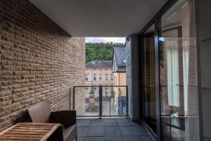 a balcony with a bench and a view of a building at DAS WESEL - DEIN HOTEL AM RHEIN in Oberwesel +52 photos
