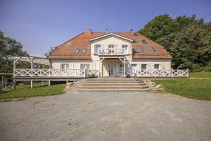 a large white house with a red roof at Ruhig und idyllische Lage, strandnah, gratis Nutzung vom AHOI Erlebnisbad und Sauna in Sellin - Gutshaus Silvitz FeWo 02 in Bergen auf Rügen