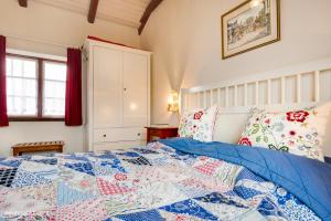 a bedroom with a bed with a blue quilt at Schlei Cottage Arnis in Sundsacker