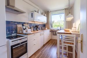 a kitchen with white cabinets and a stove top oven at Hafenblick - Kappeln in Kappeln