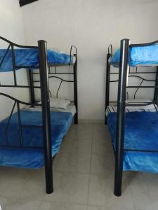 two bunk beds in a room with blue sheets at Cabaña Campestre de descanso in Melgar