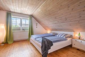 a bed in a room with a wooden ceiling at Hagensberg in Steinberg