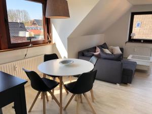 - un salon avec une table, des chaises et un canapé dans l'établissement Rosenschule 2 - OG, à Kappeln