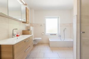 ein Badezimmer mit Waschbecken, Toilette und Badewanne in der Unterkunft Moin Moin in Nieby