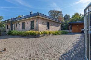 a brick house with a driveway in front of it at Moin Moin in Nieby