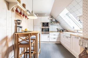 a kitchen with white cabinets and a counter with stools at Oberdeck in Maasholm