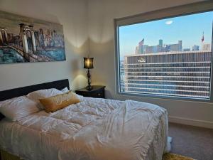 a bedroom with a bed and a large window at Luxury Highrise in Midtown - Skyline Views and Chic Decor in Houston
