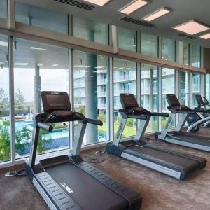 een rij loopbanden in een fitnessruimte met ramen bij Luxury Highrise in Midtown - Skyline Views and Chic Decor in Houston