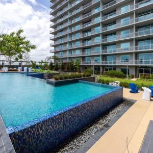 a swimming pool in front of a large building at Luxury Highrise in Midtown - Skyline Views and Chic Decor in Houston