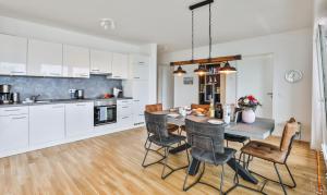 een keuken en eetkamer met een tafel en stoelen bij Küstennebel - D2 in Kappeln