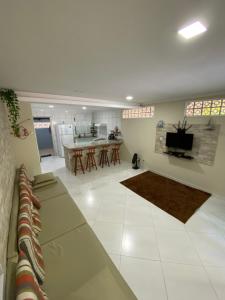 a large living room with a couch and a kitchen at Linda casa em Tarituba in Paraty