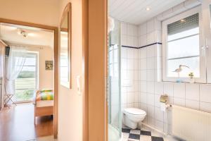a bathroom with a toilet and a window at Kronsgaard Pferdekoppel 11 in Kronsgaard
