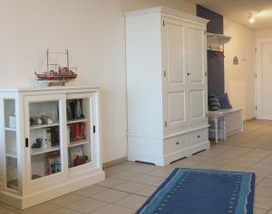a room with a white cabinet and a blue rug at Nr 17 Penthouse Meerblick in Schönhagen