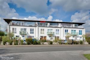 a white building with a balcony on top of it at Nr 17 Penthouse Meerblick in Schönhagen