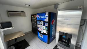 a large blue refrigerator in a room with a tv at Motel 6-Sacramento, CA - North in Sacramento