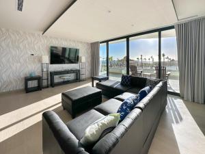 a living room with a couch and a television at Brand New 3BR Ground Floor Pool Walkout at Las Palomas in Puerto Peñasco