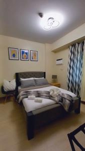 a bedroom with a bed with two towels on it at 1BR with extra room at One Regis- Megaworld in Bacolod