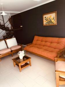 a living room with an orange couch and a table at Duplex Barrio Sur in Puerto Madryn