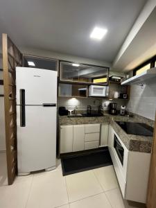 a kitchen with a white refrigerator in a room at Brisas de Tabatinga Flat in Conde