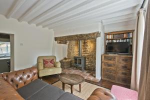 a living room with a couch and a fireplace at Japonica Cottage in East Rudham
