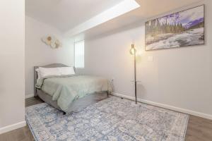 a white bedroom with a bed and a rug at Modern one bedroom apartment in Elizabeth