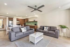 a living room with two couches and a table at Paradise Bound - A Rooftop Resort Retreat in Palm Cove