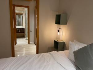 ブズニカにあるLuxury Villa Oasis, Bouznika Bayのベッドルーム1室(白いベッド1台、ランプ付)、廊下が備わります。