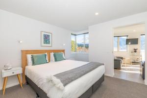 a bedroom with a large bed and a living room at Lakeside Escape in Queenstown