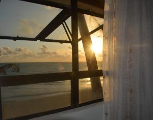 a view of the ocean from a window of a beach at Romântico com vista deslumbrante in Natal