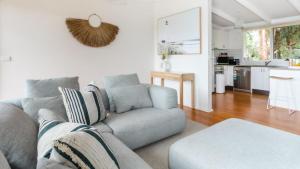 uma sala de estar com um sofá e uma cozinha em The Grove em Flinders