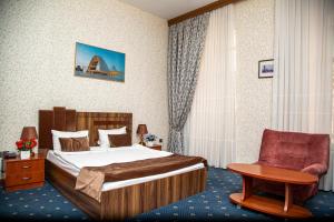 Habitación de hotel con cama y silla en Du Port Boutique Hotel en Baku