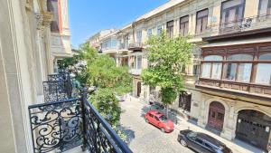 een rode auto geparkeerd in een straat naast gebouwen bij Du Port Boutique Hotel in Baku