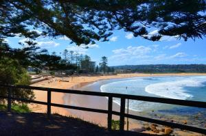 a view of a beach with people in the water at Vibrant Beachside Retreat - 2BR Unit in Freshwater in Freshwater