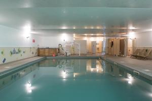 a large swimming pool with blue water in a room at Greenbanks Hotel Norfolk in Great Fransham