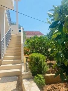 a staircase leading up to a house with trees at Apartments by the sea Necujam, Solta - 21950 in Grohote