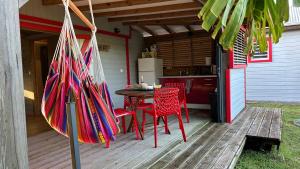 un patio avec une table et des chaises et une cuisine dans l'établissement La kaz à sucre : bungalow au calme proche de tout., à Saint-François 11 autres photos