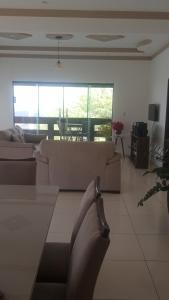 uma sala de estar com sofás e uma mesa e uma sala de jantar em Cantinho Serrano em Serra de São Bento