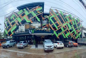 un edificio con coches estacionados en un estacionamiento en UrbanView at Lacson Street Bacolod City by RedDoorz, en Bacolod