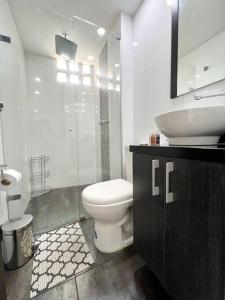 een witte badkamer met een toilet en een wastafel bij Aparta Loft La Frontera Poblado in Medellín