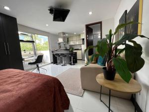 een slaapkamer met een bank en een tafel met een plant bij Aparta Loft La Frontera Poblado in Medellín