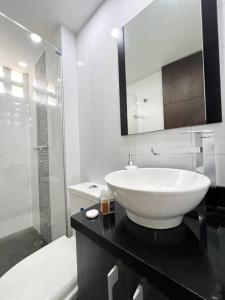 een badkamer met een witte wastafel en een douche bij Aparta Loft La Frontera Poblado in Medellín