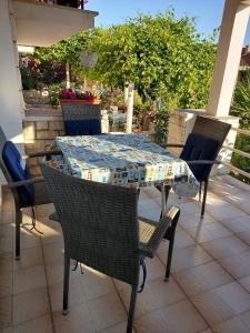 einen Tisch und Stühle auf einer Terrasse mit Tisch und Stühlen in der Unterkunft Apartments by the sea Trpanj, Peljesac - 16004 in Trpanj