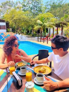 a man and a woman sitting at a table with food at CasaBosque in Tarapoto