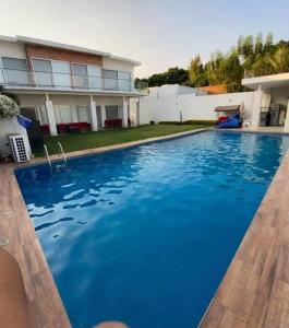 une grande piscine bleue en face d'une maison dans l'établissement HERMOSA RESIDENCIA SUMIYA,ALBERCA CLIMATIZADA, à Cuernavaca