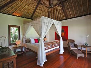 - une chambre avec un lit et une moustiquaire dans l'établissement Villa Maridadi by Elite Havens, à Canggu
